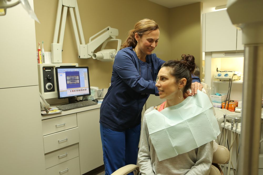 A dental hygienist with a patient at Roane Family Dental.